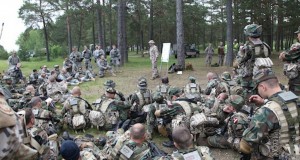 Lettische und US-Soldaten bei einer Besprechung auf offenem Feld. Bild: Flickr / US-Army Europe CC-BY 2.0